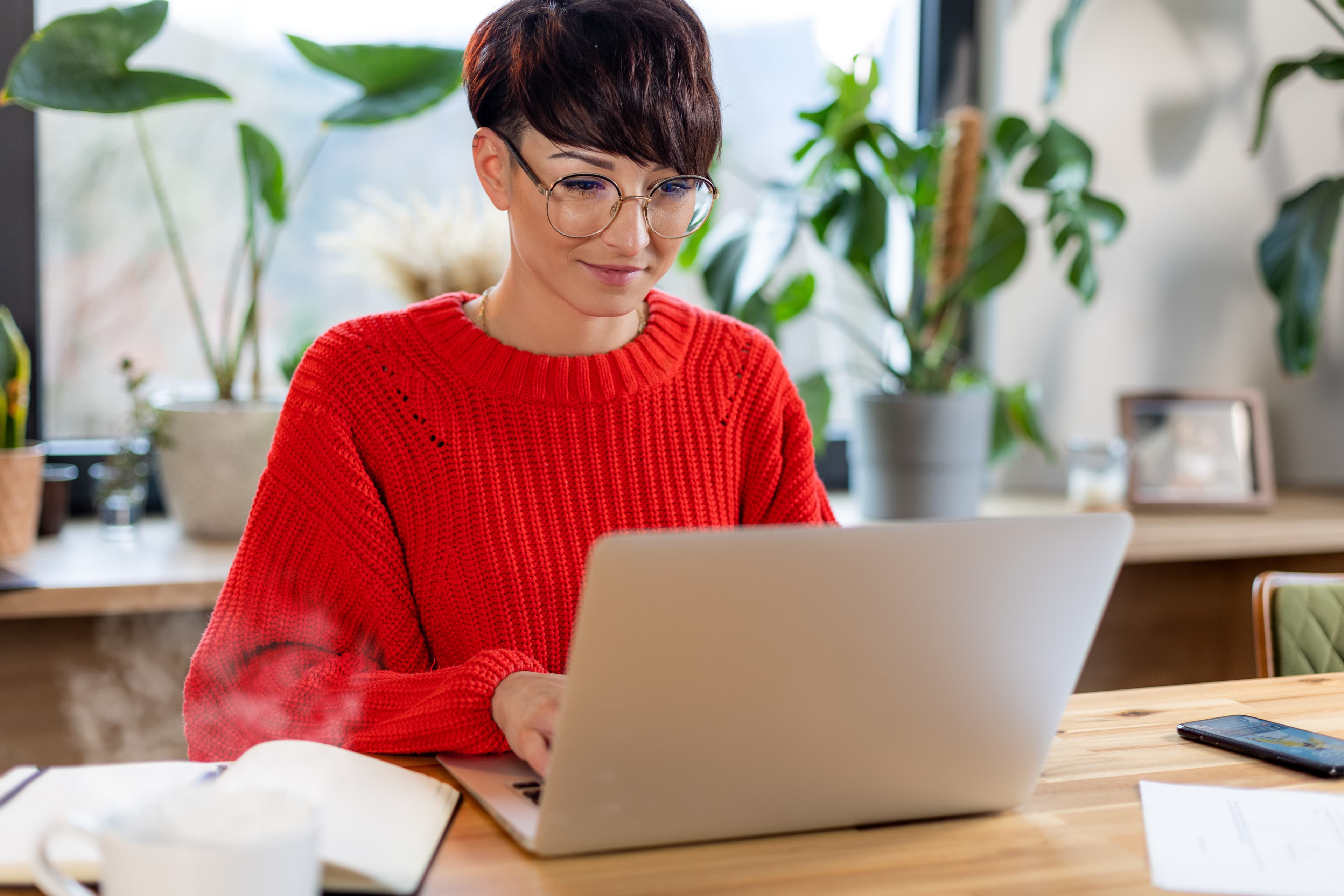 Short haired woman working from home using laptop and internet